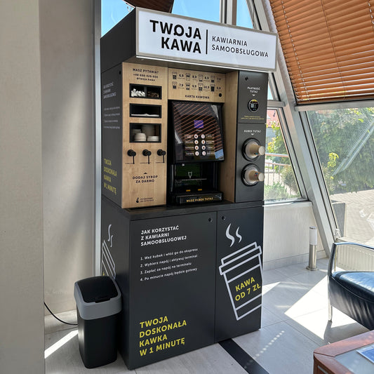 Automat do kawy samoobsługowej z panelem i ekranem, ustawiony w pobliżu okna