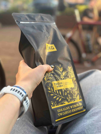 Worek z kawą ziarnistą specialty 1 kg, etykieta w złotym kolorze i liście.