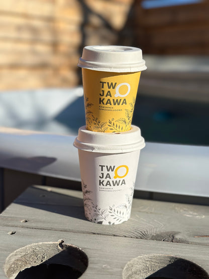 Kubki papierowe z nadrukiem „TW JA O KAWA” ułożone jeden na drugim, roślinny wzór