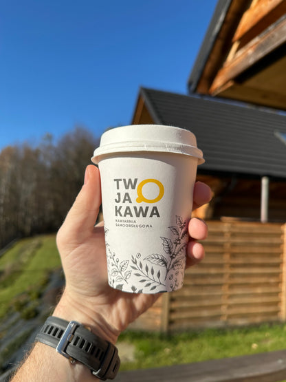 Kubek papierowy 300 ml z pokrywką, widoczny nadruk TW JA KAWA i roślinna dekoracja