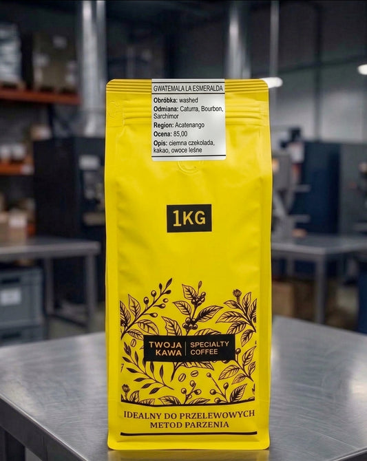 Worek z kawą ziarnistą 1 kg, żółte opakowanie z etykietą i nadrukiem.